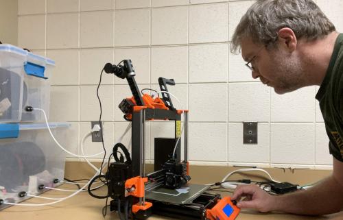 Wayne programs the 3-D printer to build the snail traps.